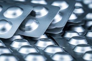 stapel tabletten pil in blisterverpakking om medicijnen tegen licht te beschermen. zilveren aluminiumfolie blisterverpakking. farmaceutische industrie. apotheek producten. terugroepen van medicijnen en terugtrekking uit het marktconcept foto