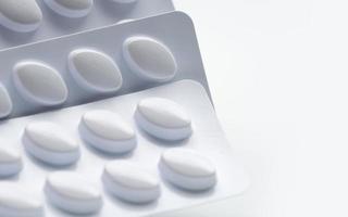 macro-opname van pillen in witte blisterverpakking voor lichte weerstand verpakking geïsoleerd op een witte achtergrond. geneesmiddel voor de behandeling van dyslipidemie. lipidenverlagende tabletten pillen. statines hyperlipidemie. foto
