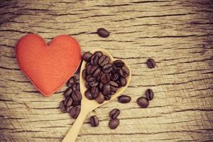 koffiebonen op houten lepel en rood hart romantische liefde Valentijnsdag op rustieke houten achtergrond liefde koffie concept foto