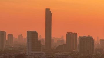 luchtvervuiling. smog en fijn stof van pm2.5 bedekte stad in de ochtend met oranje zonsopganghemel. stadsgezicht met vervuilde lucht. vuile omgeving. stedelijk giftig stof. ongezonde lucht. stedelijk ongezond leven. foto