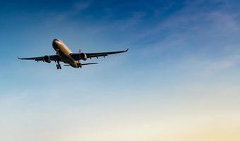 commerciële luchtvaartmaatschappij. passagiersvliegtuig landing op de luchthaven met prachtige blauwe lucht en witte wolken. Aankomst Vlucht. welkome toerist uit het buitenland. vakantietijd. fijne reis. vliegtuig dat op heldere hemel vliegt foto