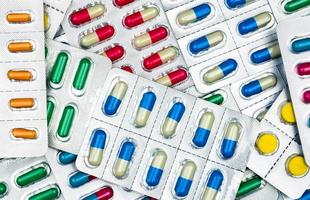 bovenaanzicht van kleurrijke tabletten en capsules pillen in blisterverpakkingen. wereldwijde gezondheidszorg en drugsgebruik met een redelijk concept. antibioticaresistentie concept. foto