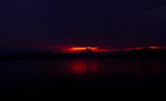 rode en paarse avondrood op de berg en het meer. mooie avondlucht. majestueuze avondrood. natuur achtergrond. kunst foto van de hemel in de schemering. zonsondergang abstracte achtergrond. schemering en dageraad concept