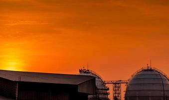 industriële gasopslagtank. lng of opslagtank voor vloeibaar aardgas. rode en oranje avondrood. sferische gastank in aardolieraffinaderij. bovengrondse opslagtank. industrie voor aardgasopslag. foto