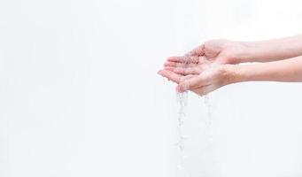 vrouw wassen hand met water geïsoleerd op een witte achtergrond. goed concept voor persoonlijke hygiëne. eerste stap om vuile handen schoon te maken om griep en coronavirus te voorkomen. volwassen vrouw met de hand weken en nat maken met water. foto