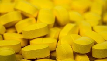 selectieve focus op stapel gele tabletten pillen. ibuprofen tabletten pillen. pijnstiller medicijn voor hoofdpijn, koorts en ontstekingsremmend. farmaceutische industrie concept. gezondheidsbeleid en budgetten. foto