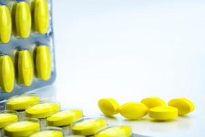 macro shot detail van gele ovale tablet pillen met blisterverpakkingen op witte achtergrond met kopie ruimte. pijnstillend medicijn. foto