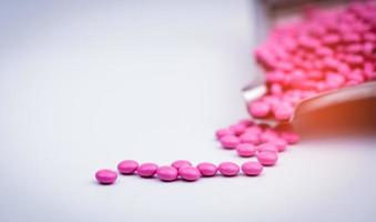 stapel roze ronde suiker gecoate tabletten pillen op drugsdienblad met kopieerruimte. pillen voor de behandeling van anti-angst, antidepressiva en migraine-hoofdpijn profylaxe. gezondheidszorg bij senioren of ouderen foto