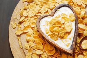 gezond ontbijt: cornflakes met melk in een houten kom foto