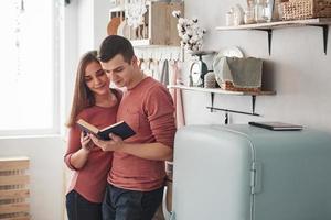 Ik weet wat we vandaag gaan koken. leuk stel dat overdag samen thuis in de keuken een boek leest foto