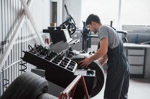 met twee handen vasthouden. jonge man werkt overdag met wielschijven in de werkplaats foto