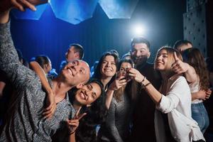geweldig feest. vrienden nemen selfie in prachtige nachtclub. met drankjes in de handen foto