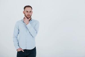 een persoon. man in officiële kleding staat tegen een witte achtergrond in de studio foto