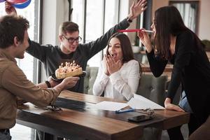 verrassing voor de mooie brunette. een van de medewerkers is vandaag jarig. vriendelijke collega's besluiten een verrassing voor haar te maken foto