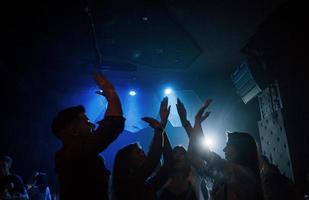 Wij zijn geweldig. groep mensen die genieten van dansen in de nachtclub met prachtige verlichting foto