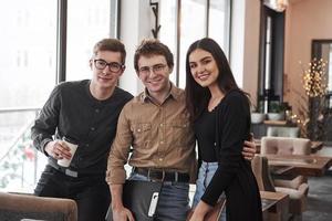 knuffelt elkaar. groep studenten met een bril die in de leerruimte staat foto