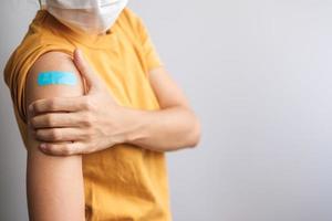 vrouw die verband toont na ontvangst van covid 19-vaccin. vaccinatie, groepsimmuniteit, bijwerking, boosterdosis, vaccinpaspoort en coronaviruspandemie foto