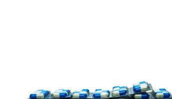 blauw-witte capsule pillen in blisterverpakking geïsoleerd op een witte achtergrond met kopie ruimte voor tekst. antibiotica resistentie tegen geneesmiddelen en gebruik van antimicrobiële geneesmiddelen met een redelijk concept. wereldwijde gezondheidszorg. foto