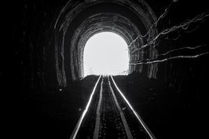 trein tunnel. oude spoorlijn in grot. hoop op leven aan het einde van de weg. spoorweg van locomotief trein in thailand. oude architectuur. spoortunnel gebouwd in 1914. reizen en hopen op de bestemming. foto