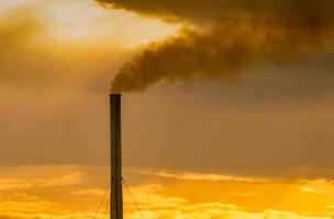 luchtvervuiling door de fabriek. rook uit de schoorsteen van industriële pijp op avondrood. opwarming van de aarde probleem concept. slechte luchtkwaliteit. emissiefactoren voor luchtverontreinigende stoffen. luchtverontreiniging. pm 2.5 stof. foto