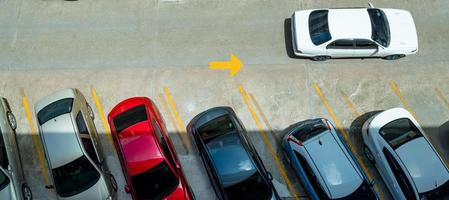 bovenaanzicht van auto geparkeerd op betonnen parkeerplaats met gele lijn van verkeersbord op straat. boven weergave van auto op een rij op parkeerplaats. geen beschikbare parkeerplaats. buiten parkeerplaats. foto