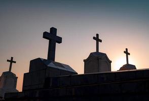 begraafplaats of kerkhof in de nacht met donkere lucht. grafsteen en kruis grafsteen begraafplaats. rust in vredesconcept. begrafenis concept. verdriet, klaagzang en dood achtergrond. spookachtige en enge begraafplaats. foto