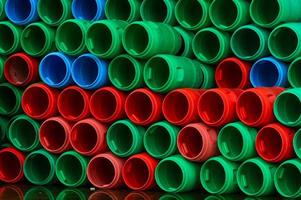 gebruikte plastic vaten. blauwe, groene en rode plastic trommel. gestapeld lege tank in voedselfabriek wachtend op recyclen en hergebruik. container van grondstof in de voedselverwerkende industrie. oude plastic trommel foto