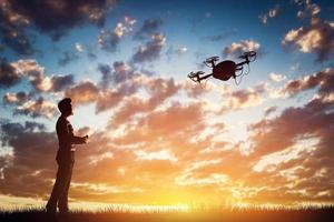 man die een drone bedient bij zonsondergang. foto