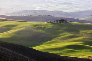 Toscane landschap bij zonsopgang. Toscaanse boerderij, wijngaard, groene heuvels. foto