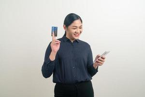 Aziatische vrouw die smartphone gebruikt met de hand met creditcard foto