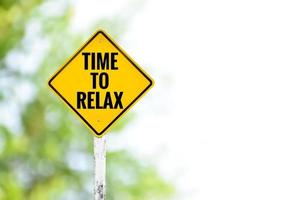 geel label verkeersbord op witte paal met de tekst 'time to relax' erop, concept om chauffeurs te informeren om te stoppen met werken en tijd door te brengen met ontspannen om geluk in het leven te brengen. foto