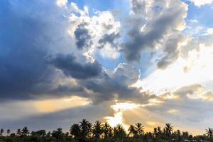 lichtstraal breekt door de dramatische lucht bij zonsondergang foto