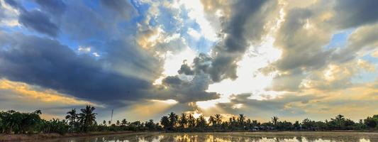 lichtstraal breekt door de dramatische lucht bij zonsondergang foto