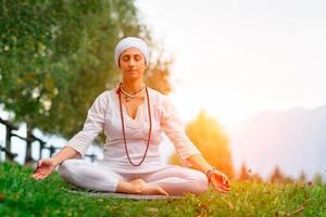 vrouw met witte jurk die yoga beoefent foto