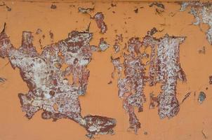 getextureerde oranje muurachtergrond met afbladderende verf foto