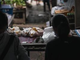 chiang mai provincie, thailand 2021 - verkoper wacht op de klant bij de verse kippenkraam op de zaterdagvlooienmarkt. foto