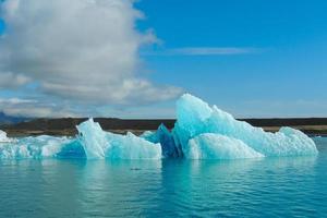 turquoise helderblauwe ijsberg drijvend in het noordzeeblauwe koude water foto