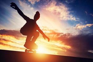 3D-man skateboarden bij zonsondergang. foto