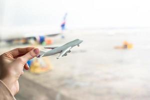 close-up hand met een vliegtuigmodel op de luchthaven foto