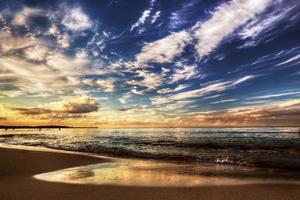 kalme oceaan onder dramatische zonsonderganghemel foto