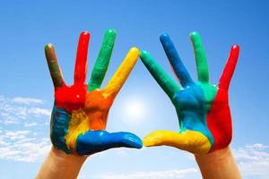 geschilderde handen, kleurrijk plezier. blauwe lucht foto