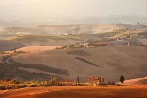 Toscane landschap bij zonsopgang. Toscaanse boerderij, wijngaard, heuvels. foto