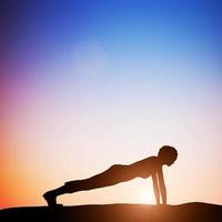 3D-vrouw in plank yoga pose mediteren bij zonsondergang. zen foto