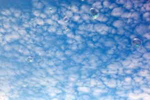 zeepbellen vliegen in de lucht. gezwollen wolken hemel. foto