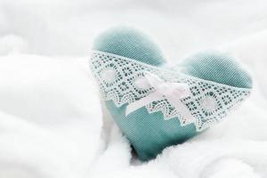 vintage handgemaakte pluche turquoise hart op de zachte witte deken foto