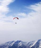 paraglider silhouet van bergen in winderige hemel op zondag