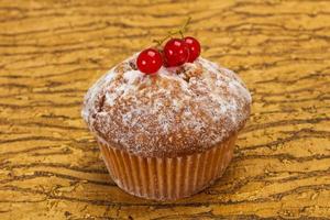 zoete smakelijke muffin met rode aalbessen foto