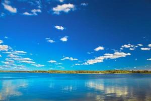 geweldig helder meer onder blauwe zonnige hemel foto