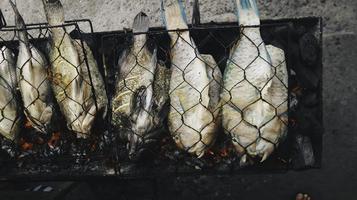 gegrilde vis met houtskool te koop op straatvoedselmarkt of restaurant in indonesië foto