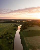 luchtfoto van een rivier en velden in de zomerochtend foto